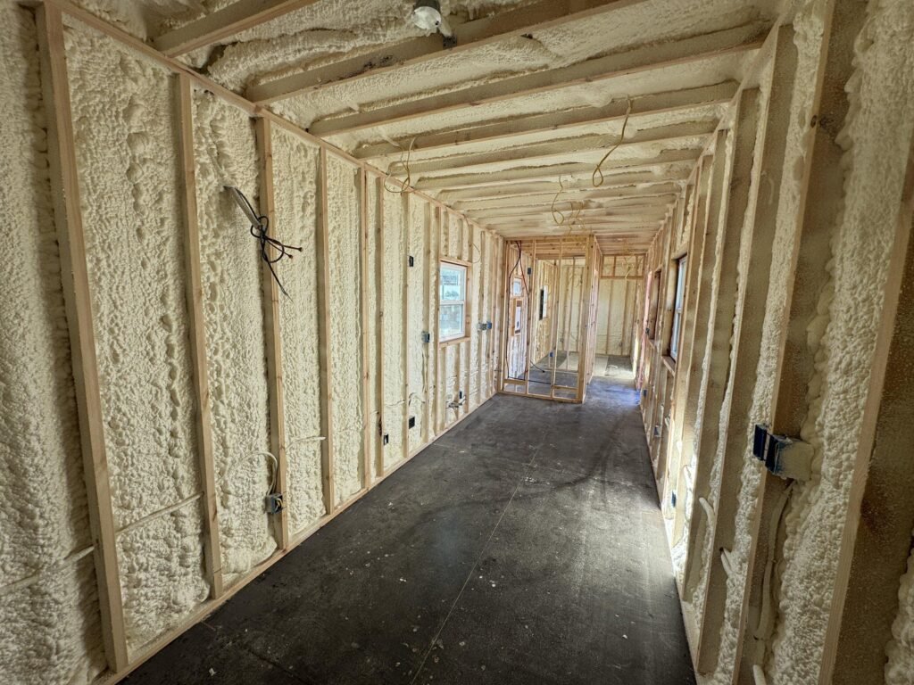 Shipping container home conversion showing insulation and interior framing before wall finishes are installed.